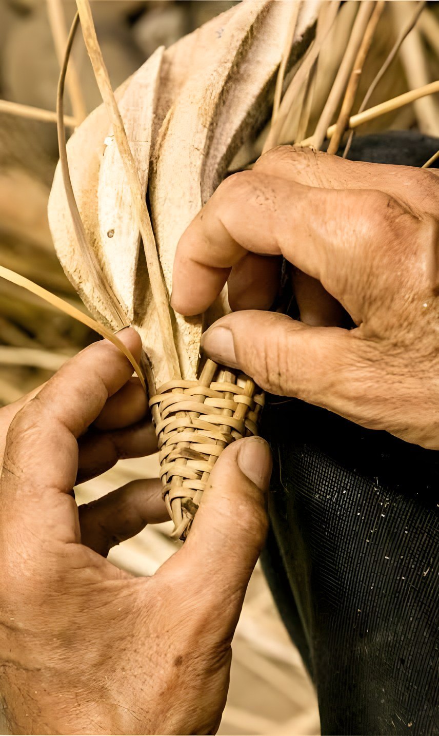 Manos de artesano tejiendo fibra natural